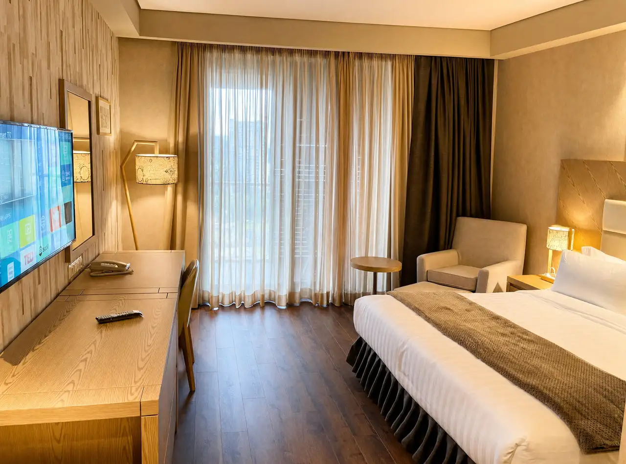 Bedroom with daylight through sheer curtains and warm wood flooring