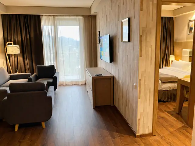 Lounge with mounted TV and direct view into the bedroom
