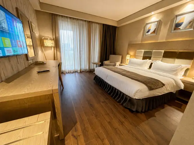 Studio Sea View & Mountain — King-size bed with wood floors, mounted TV and a reading lounge