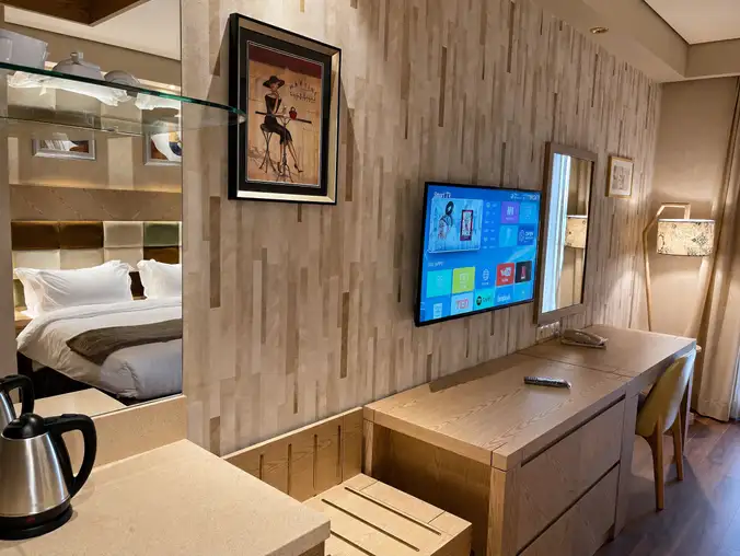 Studio Sea View & Mountain — Workspace with smart TV, vanity and mirror reflecting the bedroom