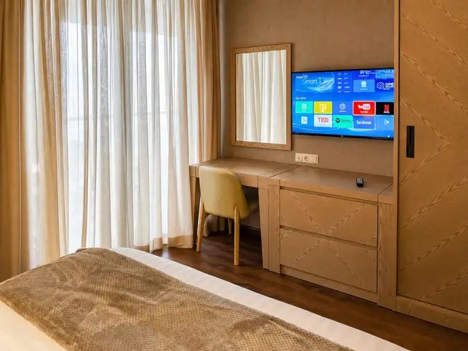 One Bedroom Sea Front & Batumi Side — Bedroom desk with mirror and smart TV beside the king bed