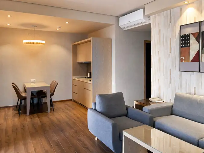 One Bedroom Sea Front & Batumi Side — Kitchenette with oak cabinetry, dining table and pendant lighting